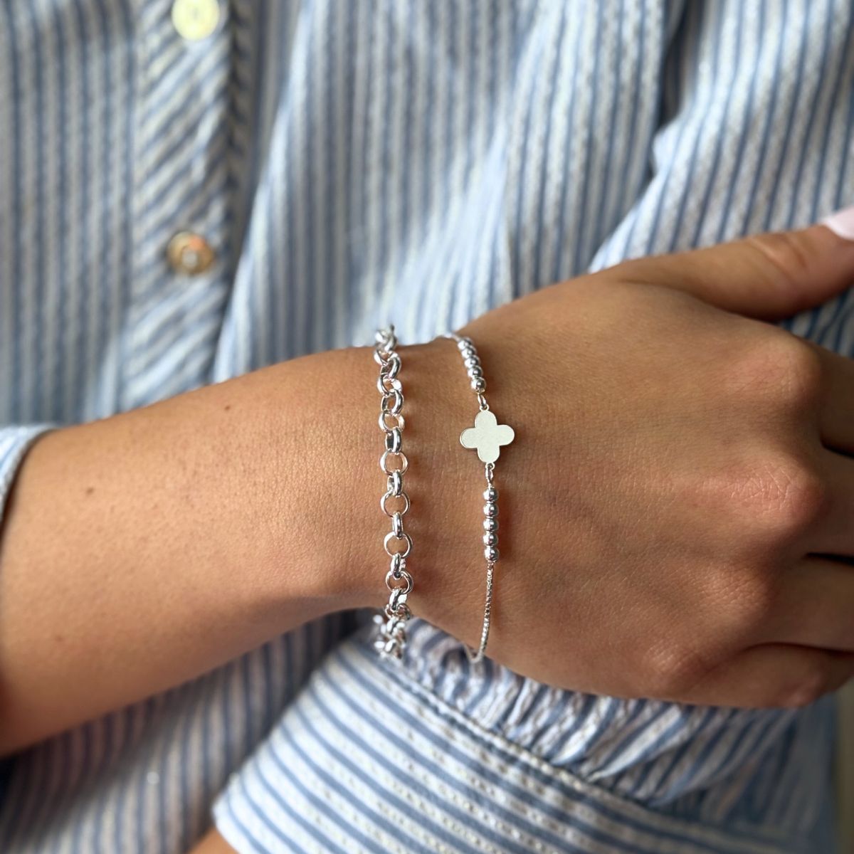 Pulsera Rolo en modelo moderno acompañada de la pulsera flor de plata 925 de AMBAR Joyería Fina