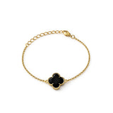 Pulsera de oro laminado con dijes de flor de cuatro pétalos texturizados y centros de color negro brillante sobre fondo blanco.