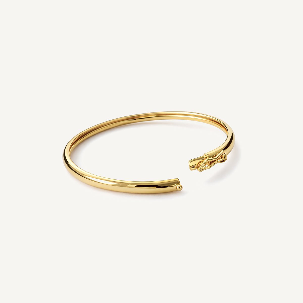 Brazalete rígido tipo puñera de oro laminado.