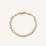 Pulsera de cadena tipo clip plana fabricada en oro laminado de alta calidad sobre fondo blanco.