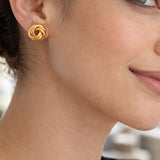 modelo con Aretes tipo topo de plata de ley 925 con enchape de oro 18k en diseño de nudo texturado