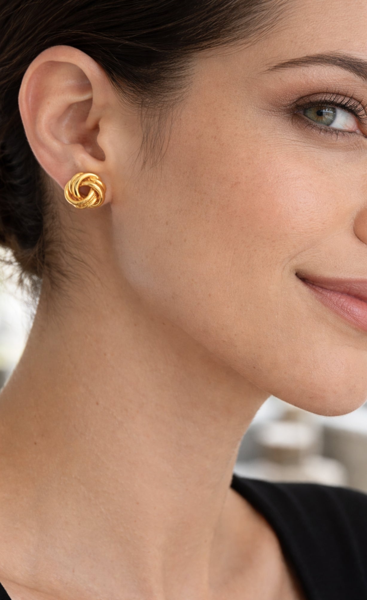 modelo con Aretes tipo topo de plata de ley 925 con enchape de oro 18k en diseño de nudo texturado