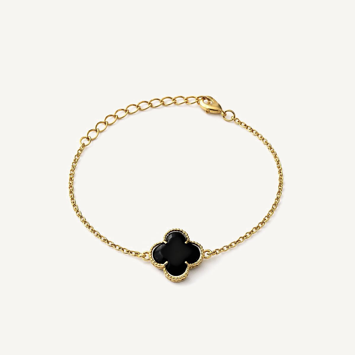 Pulsera de oro laminado con dijes de flor de cuatro pétalos texturizados y centros de color negro brillante.