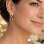Modelo luciendo aretes geométricos Marlis en oro laminado.