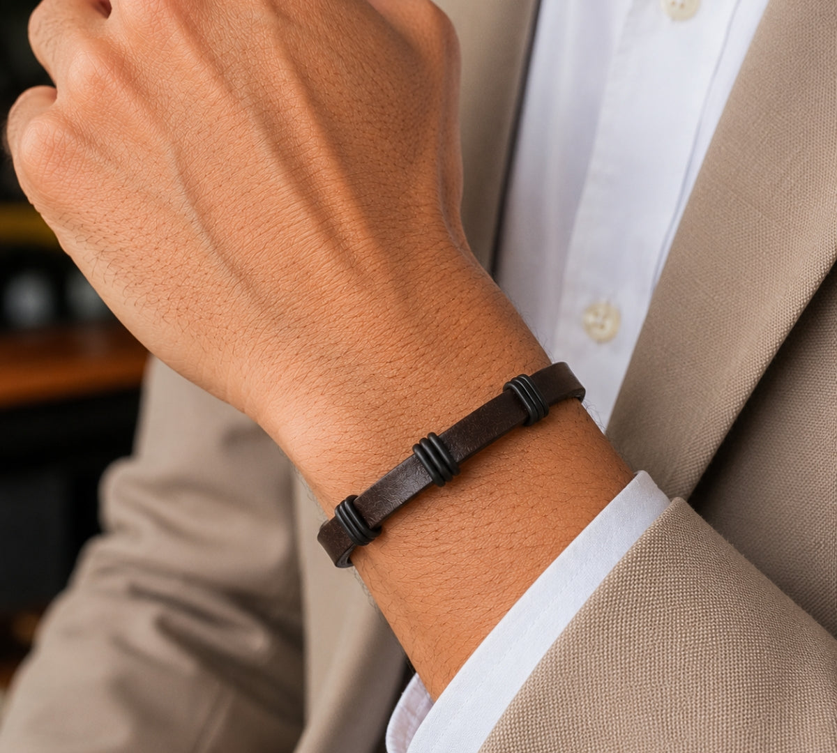 modelo con pulsera de cuero marrón para hombre con tres separadores negros de acero y broche magnético rectangular.