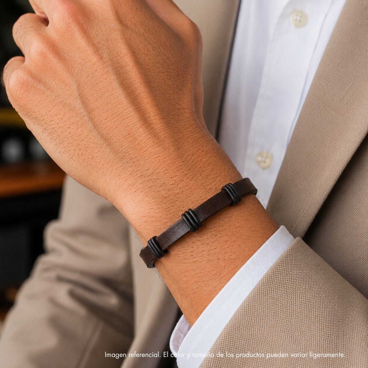modelo con pulsera de cuero marrón para hombre con tres separadores negros de acero y broche magnético rectangular.
