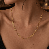 Modelo luciendo el collar de cadena clip plano de plata enchapada en oro 18k, resaltando un estilo sofisticado y moderno.