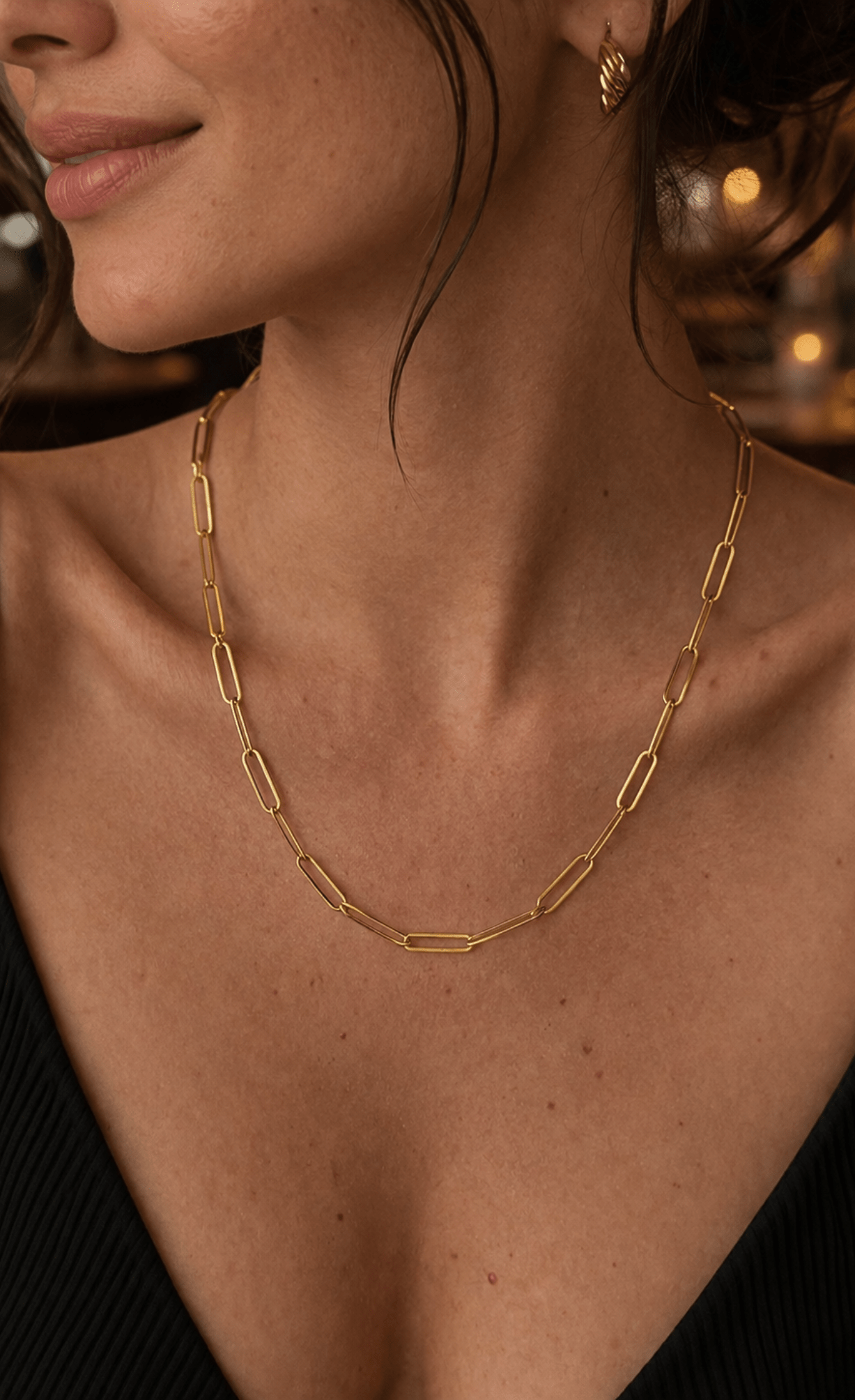 Modelo luciendo el collar de cadena clip plano de plata enchapada en oro 18k, resaltando un estilo sofisticado y moderno.