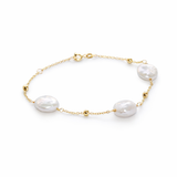 Pulsera de cadena fina en oro 18k con tres perlas barrocas blancas de forma orgánica, accesorio de joyería fina para mujer.