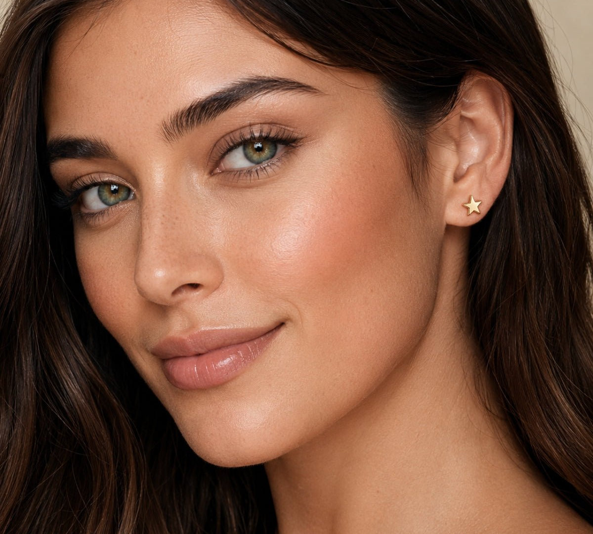 modelo luciendo Arete estrella enchapado en oro 18k y poste de acero para joyería de AMBAR joyería fina