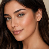 modelo luciendo Arete estrella enchapado en oro 18k y poste de acero para joyería de AMBAR joyería fina