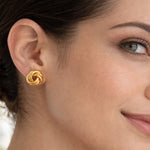 modelo con Aretes tipo topo de plata de ley 925 con enchape de oro 18k en diseño de nudo texturado