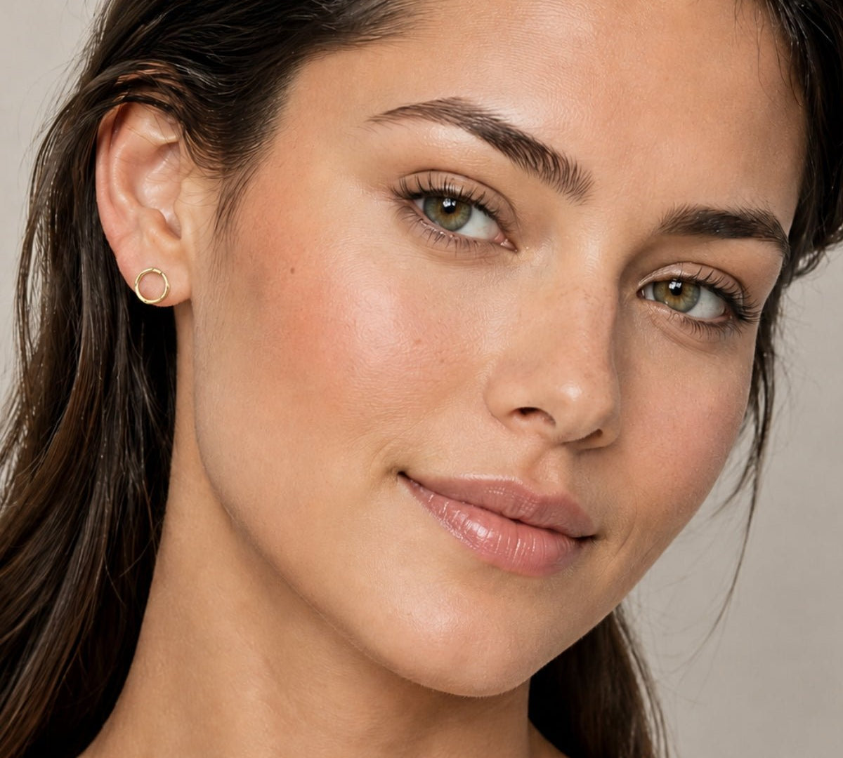 modelo luciendo Aretes aro de forma orgánico enchapados en oro 18K de AMBAR joyería fina