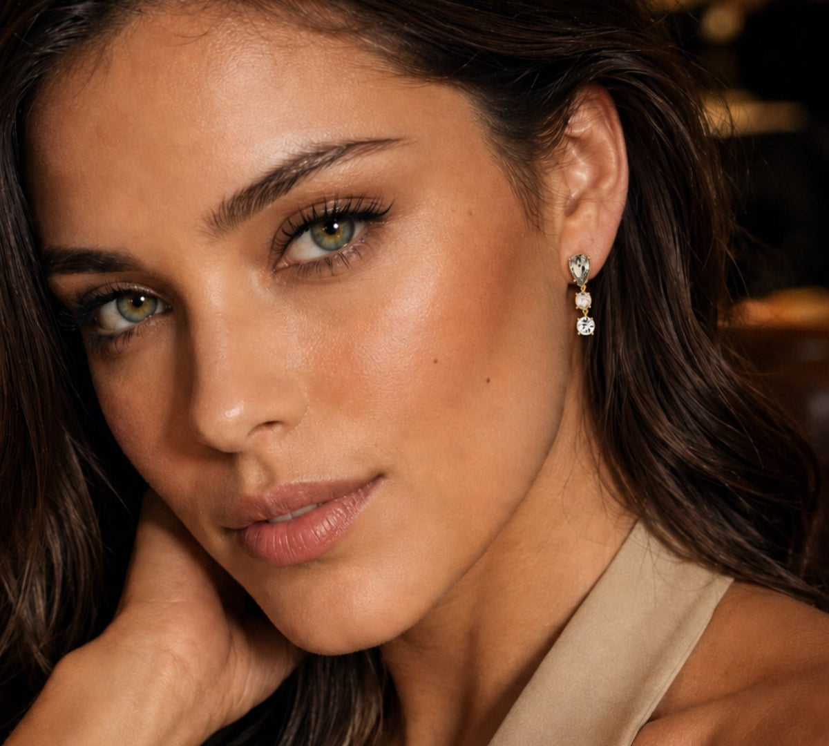 modelo luciendo nuestros Aretes colgante de pera Lexi enchapado en oro de 18K de AMBAR Joyería Fina