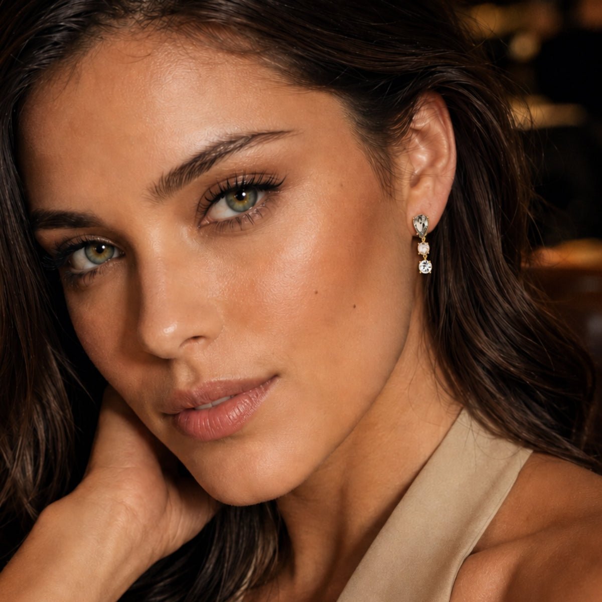 modelo luciendo nuestros Aretes colgante de pera Lexi enchapado en oro de 18K de AMBAR Joyería Fina