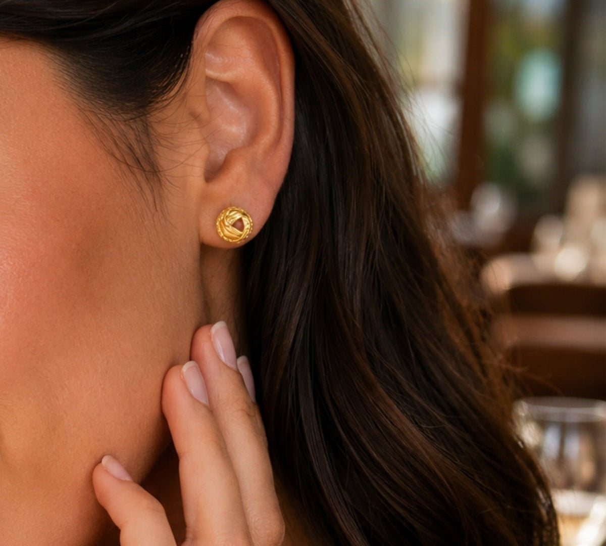 modelo en close up de  aretes de oro laminado modelo canastilla con textura labrada de AMBAR joyería