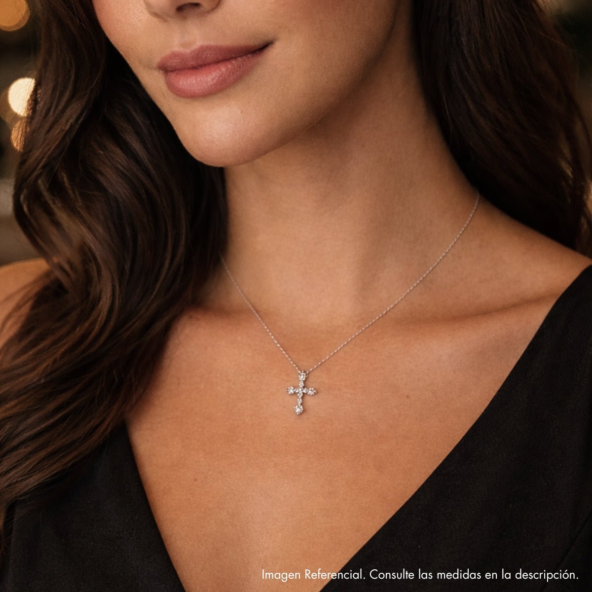 Modelo con collar con dije de cruz de plata 925 enchapada en rodio y circonitas brillantes.
