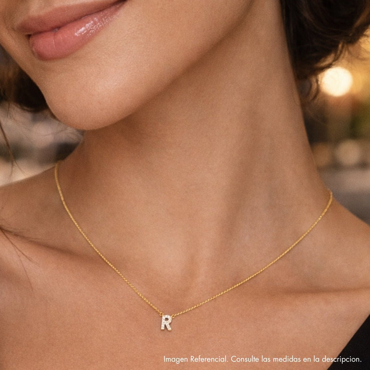 Modelo luciendo collar de inicial R en plata 925 con acabado de Oro 18k.