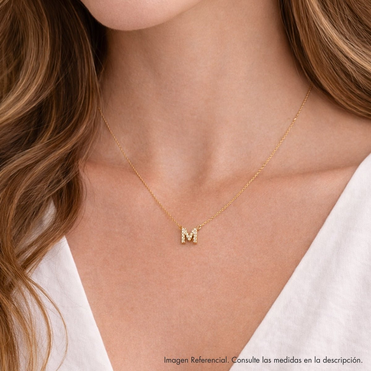 Modelo luciendo collar de inicial M en plata 925 con acabado de Oro 18k.