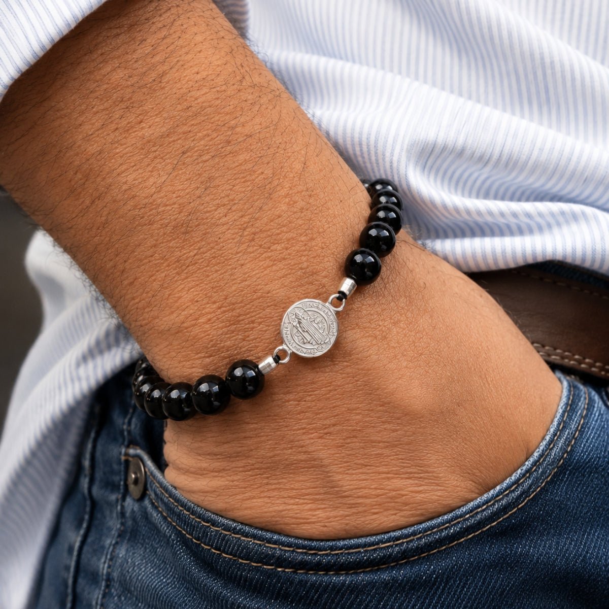 modelo con Pulsera San Benito tejida regulable con turmalina negra natural de 8 mm y accesorios de plata 950.
