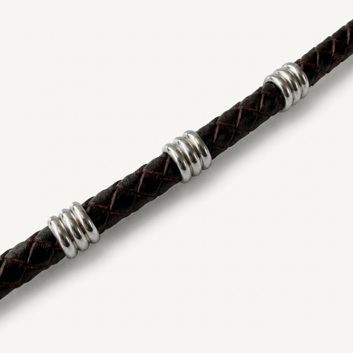 detalle de Pulsera Atlas de cuero trenzado marrón chocolate de 6 mm con broche magnético y detalles en acero inoxidable.
