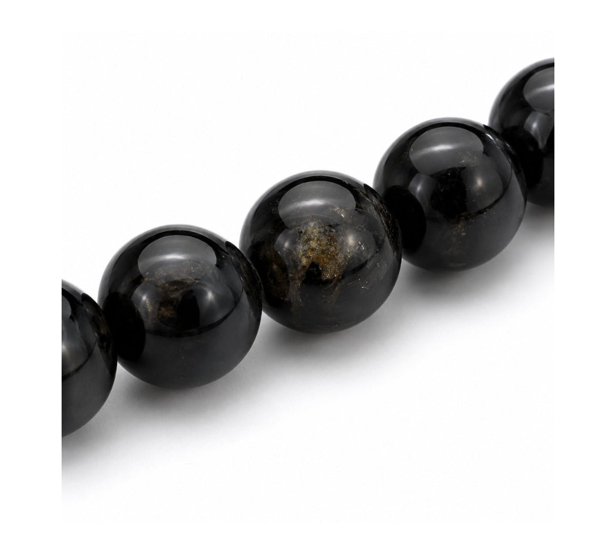Primer plano de las esferas pulidas de piedra natural turmalina negra con detalles de brillo natural de la pulsera elástica Orión.