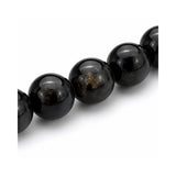 Primer plano de las esferas pulidas de piedra natural turmalina negra con detalles de brillo natural de la pulsera elástica Orión.