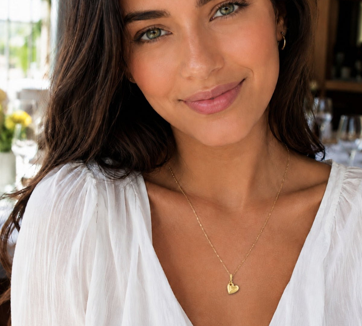 Modelo luciendo un Dije Lou Corazón con broche bisagra enchapado en oro 18K de AMBAR Joyería Fina
