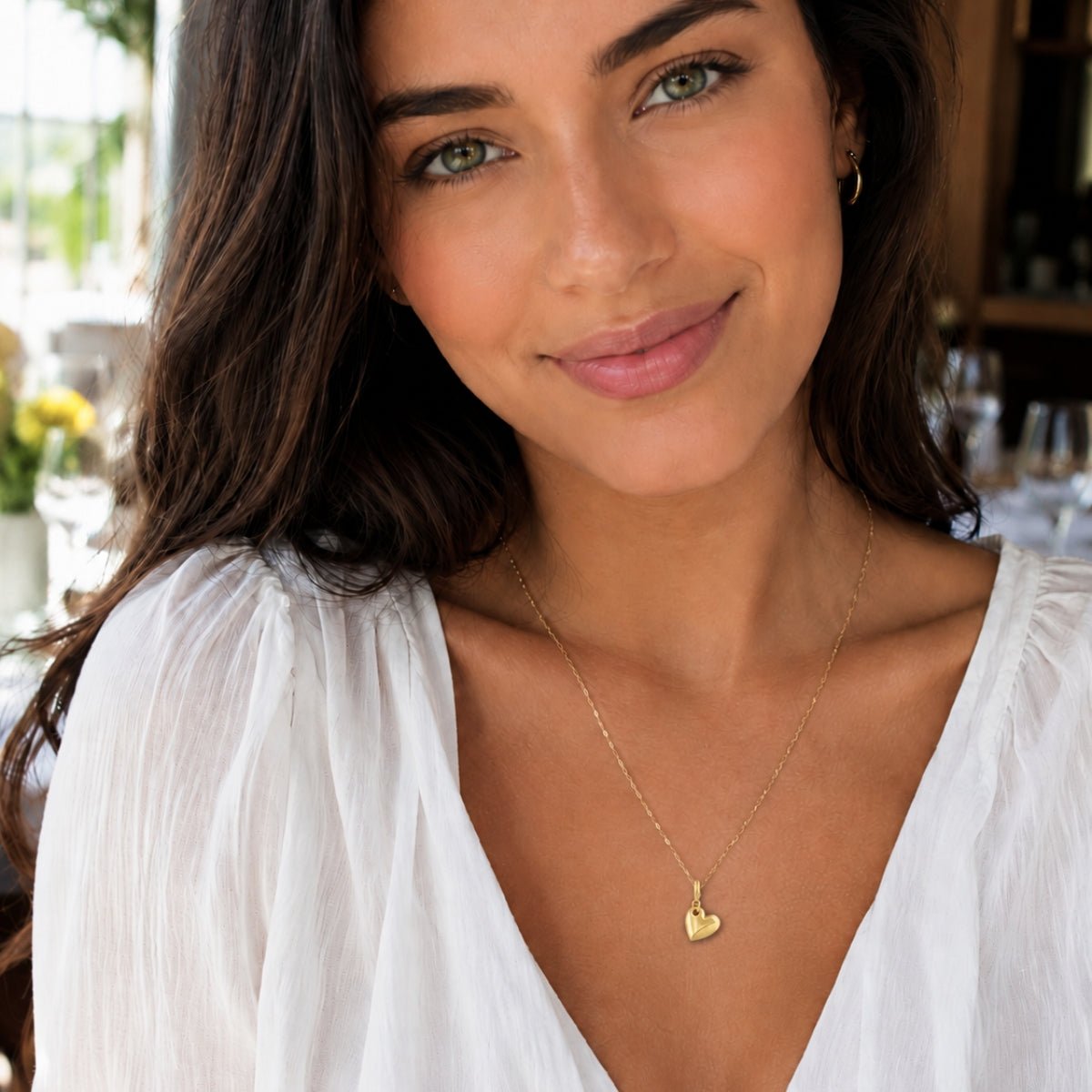 Modelo luciendo un Dije Lou Corazón con broche bisagra enchapado en oro 18K de AMBAR Joyería Fina