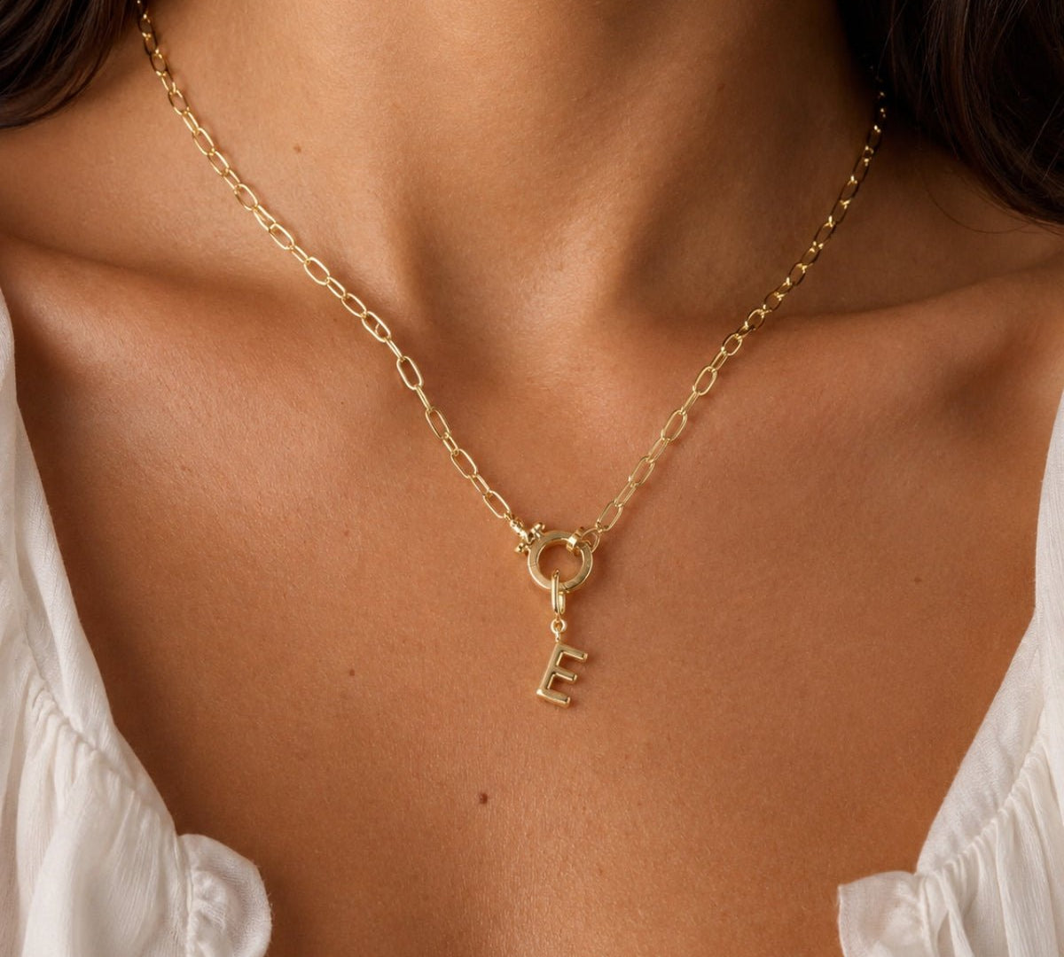 modelo luciendo un Dije Inicial letra E con broche bisagra enchapado en oro 18k de AMBAR joyeria fina