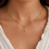 modelo luciendo Dije Inicial letra H con broche bisagra enchapado en oro 18k de AMBAR joyeria fina