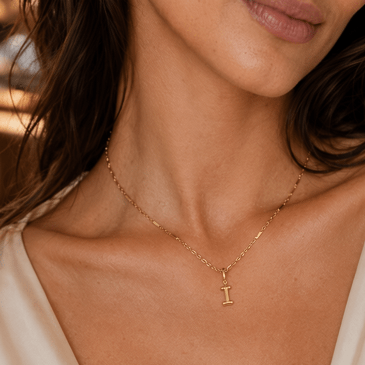 modelo luciendo un Dije Inicial letra I con broche bisagra enchapado en oro 18k de AMBAR joyeria fina