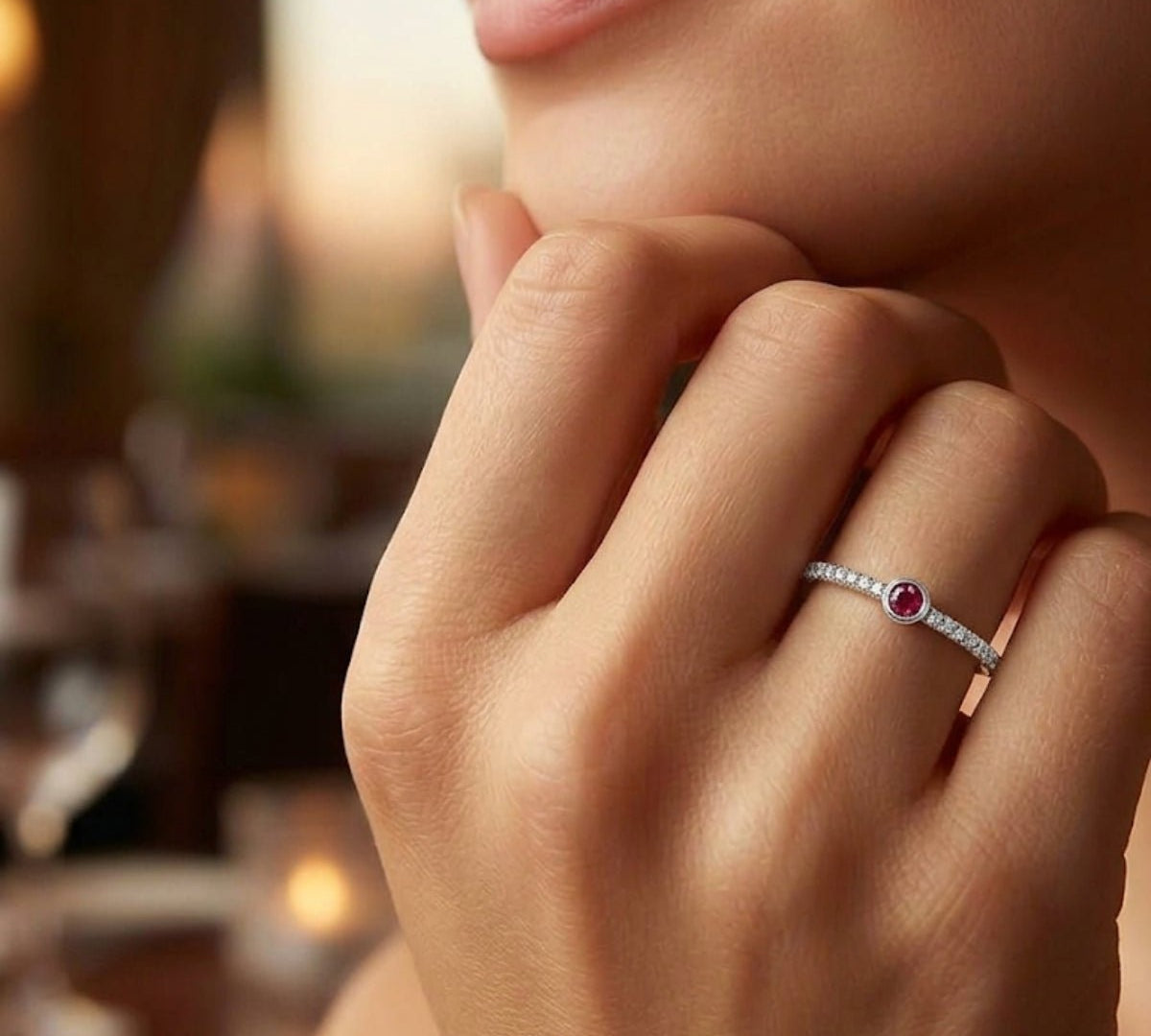 Detalle de mano luciendo anillo fino semi rivier de plata 925; joyería elegante y minimalista.