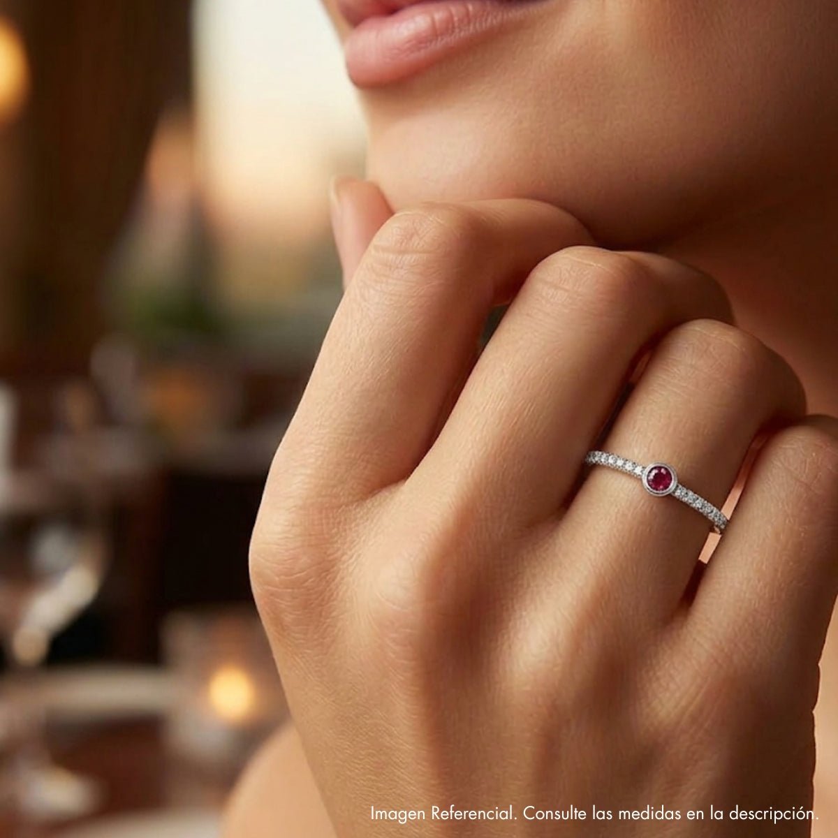 Detalle de mano luciendo anillo fino semi rivier de plata 925; joyería elegante y minimalista.