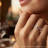 Detalle de mano luciendo anillo fino semi rivier de plata 925; joyería elegante y minimalista.