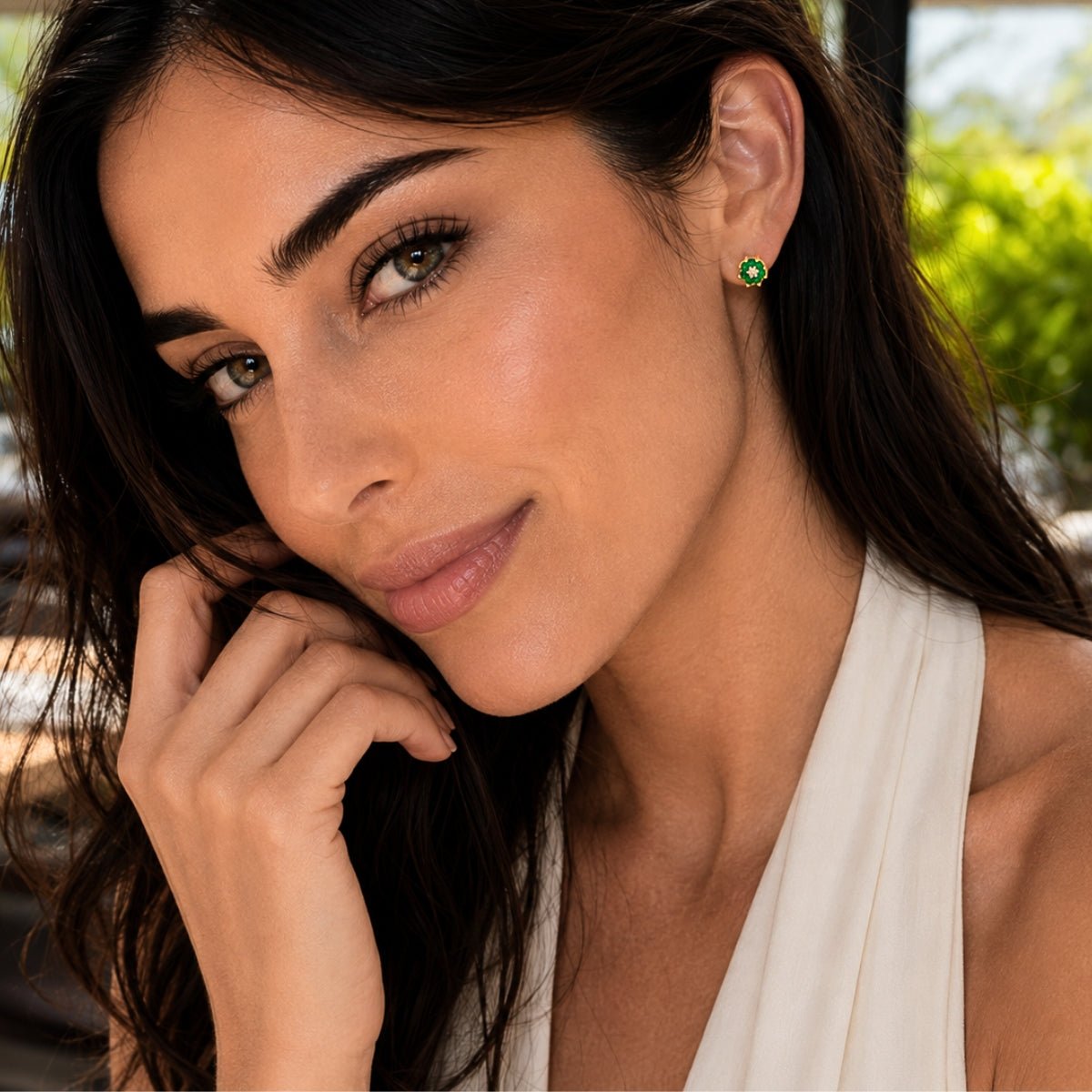 modelo luciendo arete roseta verde esmeralda con cristales y oro laminado de ambar joyería