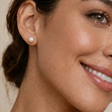Modelo luciendo aretes de perla clásicos; joyería en gold filled para un look elegante y atemporal.