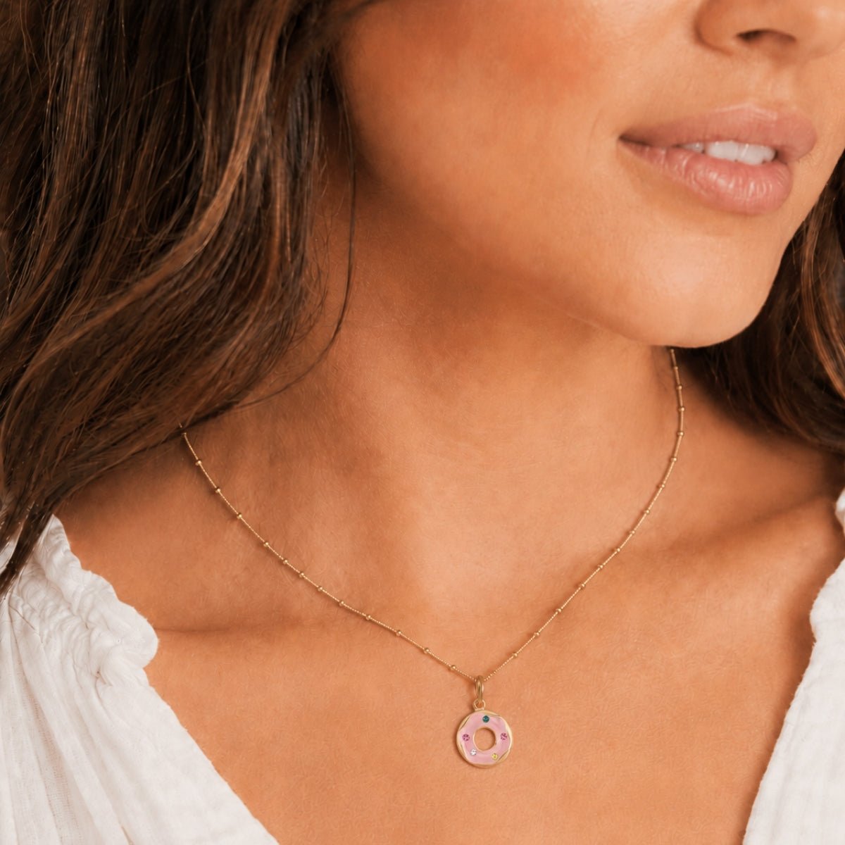 modelo luciendo nuestro Dije Donut Trendy enchapado en oro de 18K de AMBAR Joyería Fina