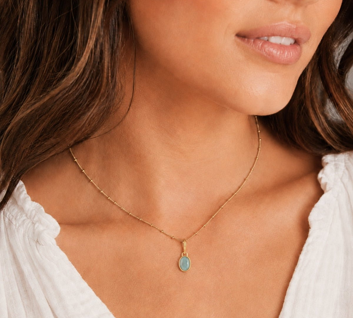 modelo luciendo un dije power gemstone Aguamarina piedra del coraje enchapado en oro 18K de AMBAR Joyería Fina
