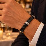 modelo con Pulsera Cuero Trenzado Urban de cuero negro con broche y accesorios de acero inoxidable y bandas de silicona negra.