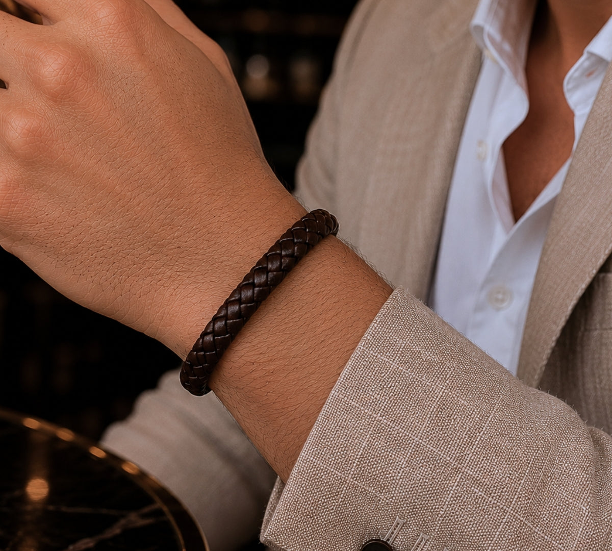 modelo con un pulsera de cuero trenzado marrón y broche elegante de  acero.