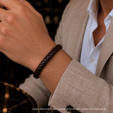 modelo con un pulsera de cuero trenzado marrón y broche elegante de  acero.