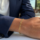 Pulsera de oro laminado para hombre con eslabones planos entrelazados Monaco Flat lucida en la muñeca de un caballero.