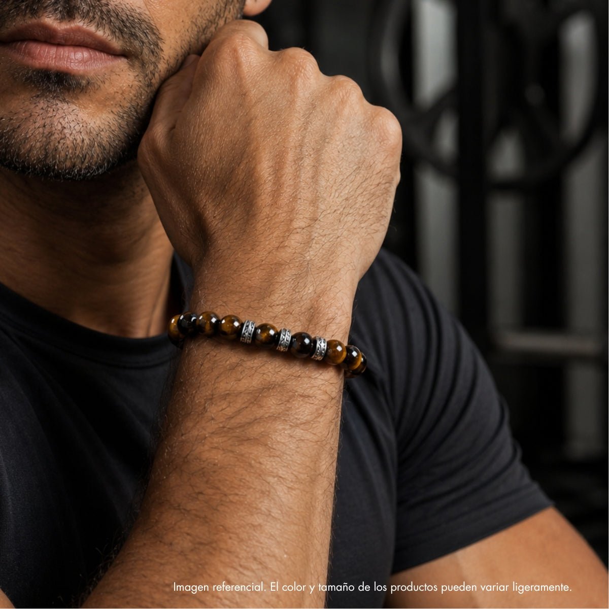 Modelo con pulsera elástica para hombre modelo Hermes con hilo de silicona, esferas ojo de tigre y tres aros texturizados de plata 925.