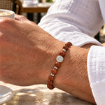modelo con Pulsera San Benito Aura con piedra Lluvia de Oro de 8 mm, dije San Benito y aplicaciones de Plata 925.