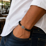 modelo con Pulsera San Benito tejida regulable con ónix mate natural de 8 mm y accesorios de plata 950.