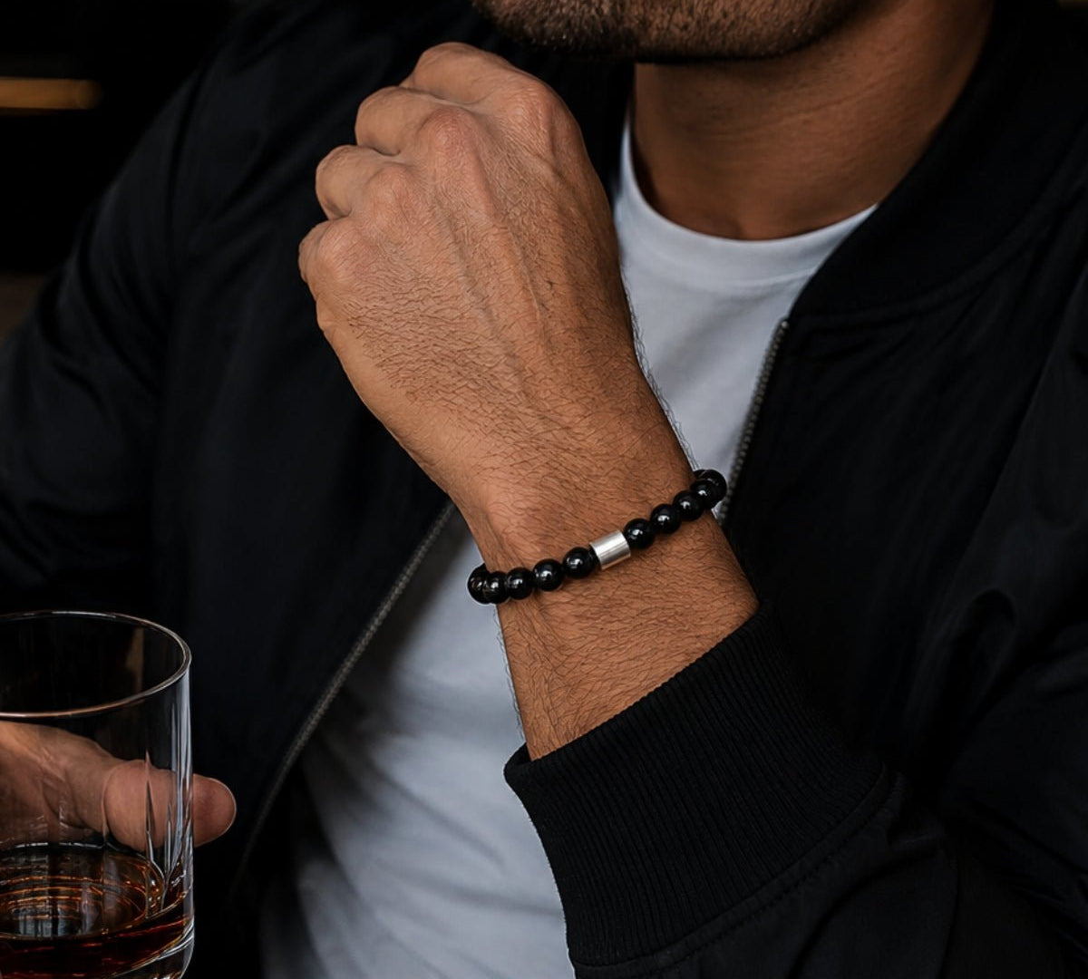 modelo con pulsera elástica para hombre modelo Orión con hilo de silicona, esferas de turmalina negra pulida y tubo cilíndrico central de plata 925.