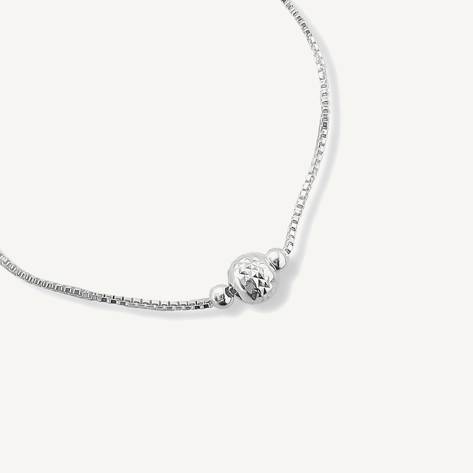 detalle de pulsera regulable bolita facetada de plata 925.