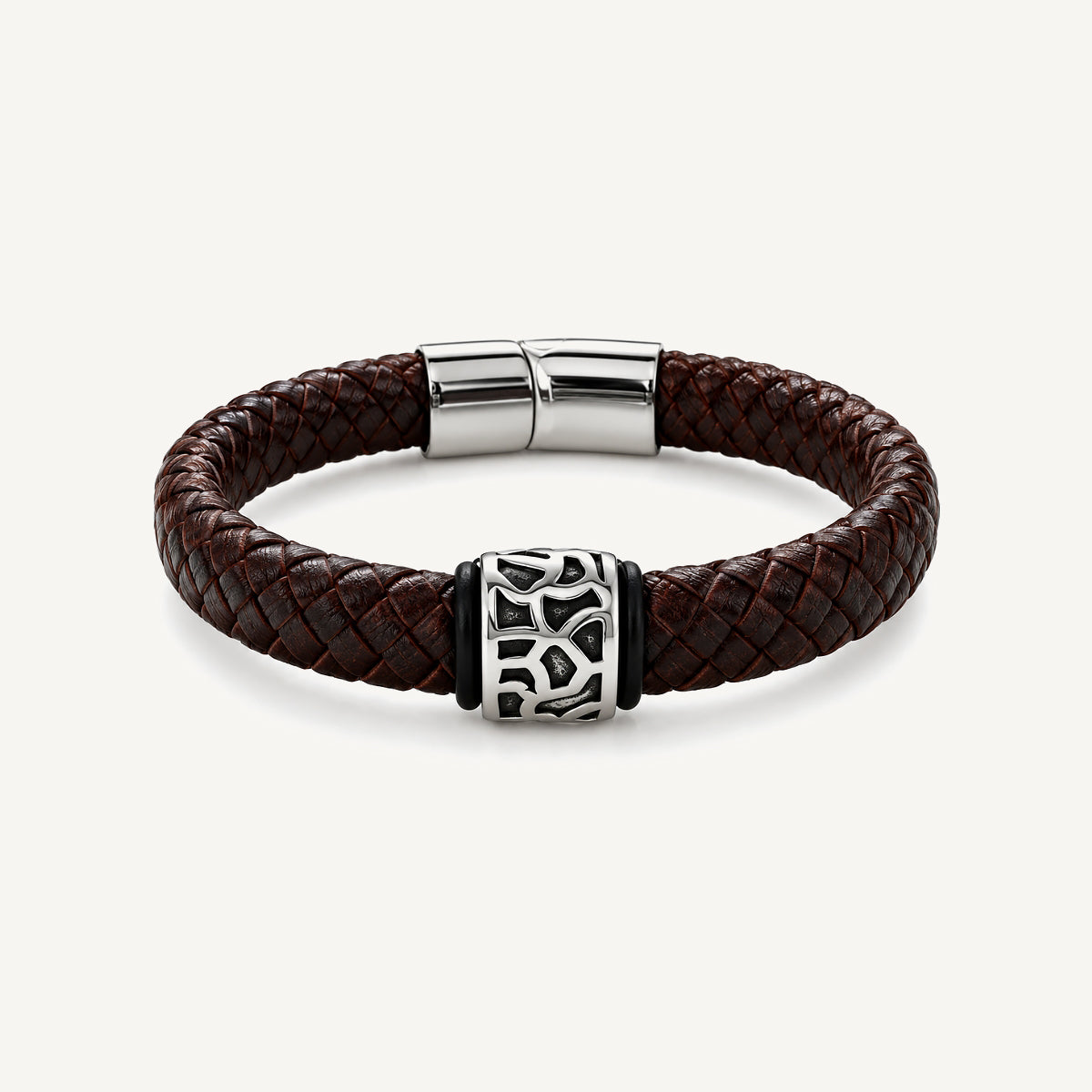 Pulsera Cuero Trenzado Vulcano de cuero marrón con aplique central de acero inoxidable texturizado y bandas de silicona negra.