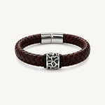 Pulsera Cuero Trenzado Vulcano de cuero marrón con aplique central de acero inoxidable texturizado y bandas de silicona negra.